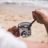 Barista & Co Brew It Stick Coffee and Tea Infuser on the go in an enamel mug