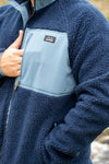 Sherpa fleece in navy pocket with mans hand partly inside