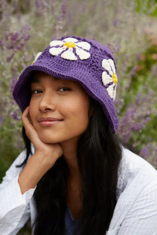 Pachamama_Daisy_Bucket_Hat_in_Purple_On_Woman_With_Face_Rested_On_Palm