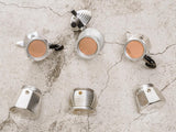 A Cafe Concetto Moka Filter Disc - Superfine 57.5mm shown being used with various compatible coffee makers and how they fit in the top section of the device.