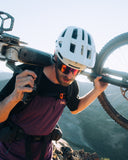 Mons Royale Mens Diversion Merino Bike Jersey Short Sleeve in the colour Boysenberry / Black, shown on a model carrying a dirtbike