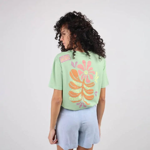 Oxbow TAHCAT Tee-shirt in Palmier on woman showing back graphic of flower in pink, yellow, orange and purple. 