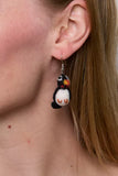 Pachamama Puffin Earrings, shown on a model, up close