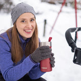 Primus Slurken Vacuum Mug 0.4L shown in the colour red shown being used by a lady outdoors