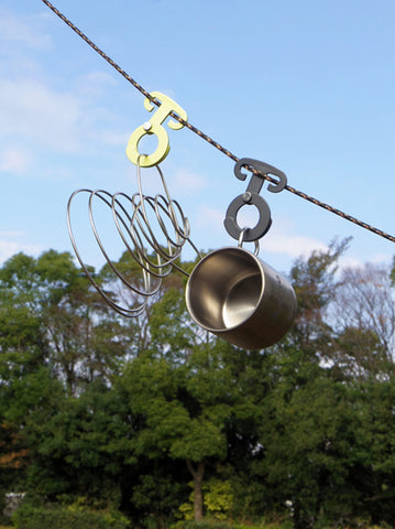 SOTO Gravity Hanger shown in use, hanging camping eaccessories from a line