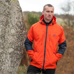 Hilltrek Talorc Organic Hybrid Jacket in Blaze/Orange on male model by a celtic stone.