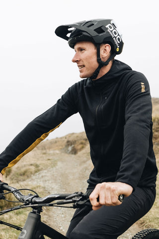 Mons Royale Approach Merino Shift Fleece Hood in the colour Black shown with the hood down mountain biking