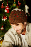 Pachamama Christmas Pudding Hat on hunky man by a Christmas tree