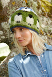 Pachamama Flock of Sheep Beanie on a blond model standing in front of a tree.