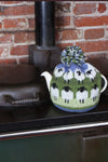 Pachamama Flock of Sheep Tea Cosy sitting on a stove
