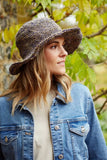 Pachamama Hemp/Cotton Sun Hat with wire brim shown in the colour Denim with a model glancing to the side