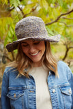 Pachamama Hemp/Cotton Sun Hat with wire brim shown in the colour Denim showing the model laughing
