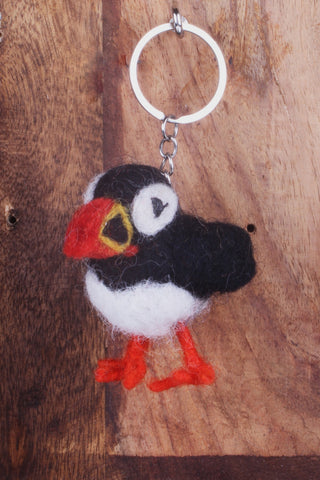 Pachamama Paul The Puffin Keyring hanging off a hook on a wooden background