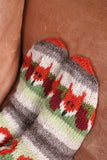 Pachamama Skulk Of Foxes Sofa Socks showing the toe tips on a brown sofa cushion